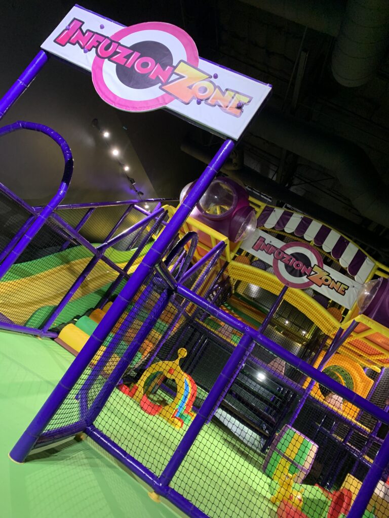 Indoor kids' play area with colorful slides and climbing frames.