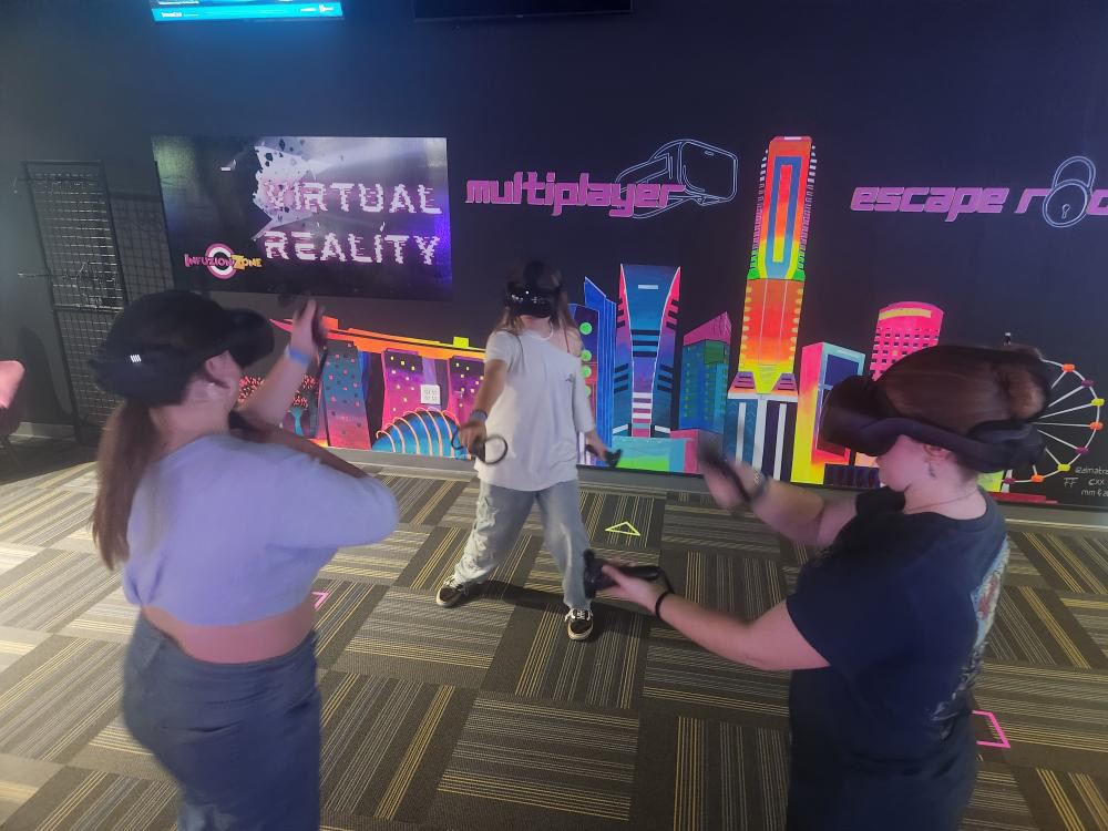 People exploring a neon-lit virtual reality arcade with VR headsets.